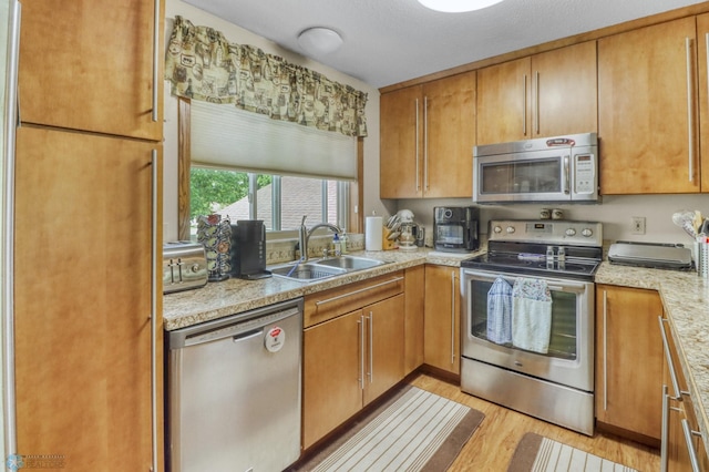 2744 32nd St S, Moorhead, MN 56560 - kitchen with stainless steel appliances, light wood finished floors, and brown cabinets