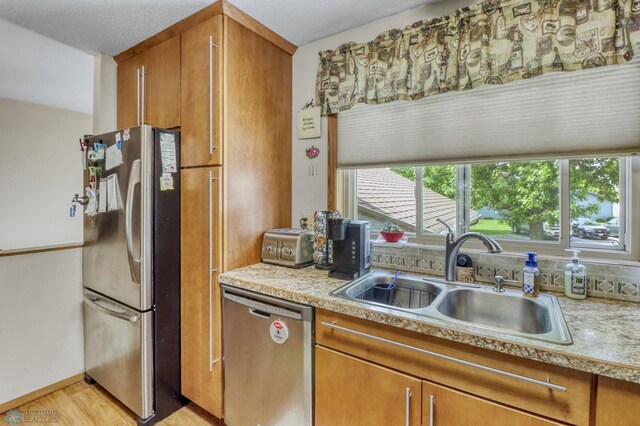 2744 32nd St S, Moorhead, MN 56560 - kitchen with appliances with stainless steel finishes, brown cabinets, light countertops, and plenty of natural light