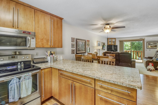 2744 32nd St S, Moorhead, MN 56560 - kitchen with appliances with stainless steel finishes, a peninsula, light countertops, and light wood finished floors
