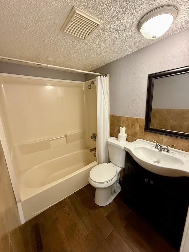 1212 Gorton Ave NW, Willmar, MN 56201 - bathroom with a textured ceiling, tile walls, shower / bath combo, wood finished floors, and vanity