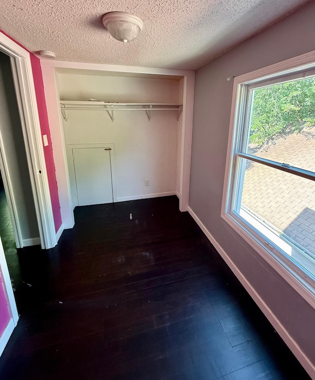 1212 Gorton Ave NW, Willmar, MN 56201 - unfurnished bedroom featuring a closet, a textured ceiling, and dark wood-style flooring