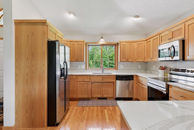 15450 Goodview Ave N, Hugo, MN 55038 - kitchen with appliances with stainless steel finishes, light countertops, light wood-style flooring, and a textured ceiling