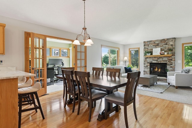 15450 Goodview Ave N, Hugo, MN 55038 - dining area featuring light wood-style flooring, a stone fireplace, and french doors