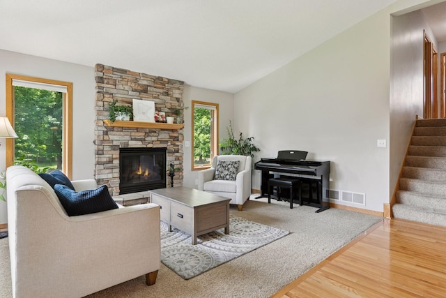 15450 Goodview Ave N, Hugo, MN 55038 - living area featuring wood finished floors, stairway, a stone fireplace, and lofted ceiling
