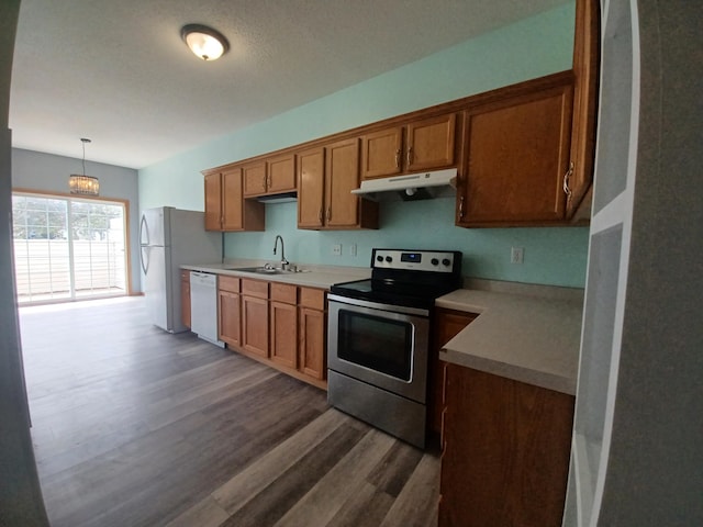 21196 Morgan Dr, Forest Lake, MN 55025 - kitchen featuring white appliances, under cabinet range hood, dark wood-type flooring, brown cabinets, and light countertops