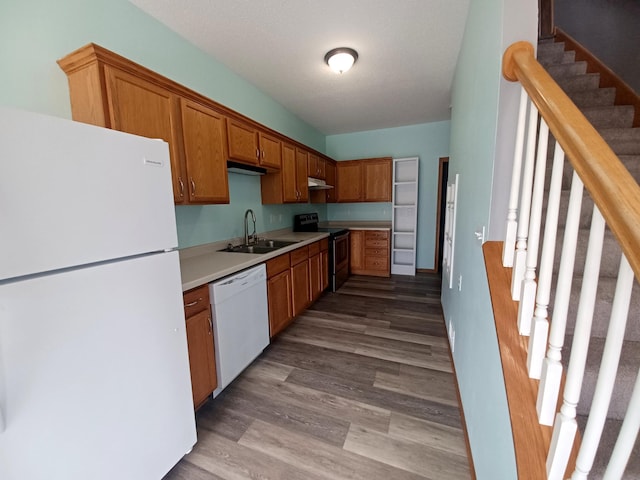 21196 Morgan Dr, Forest Lake, MN 55025 - kitchen with white appliances, light countertops, wood finished floors, brown cabinetry, and under cabinet range hood