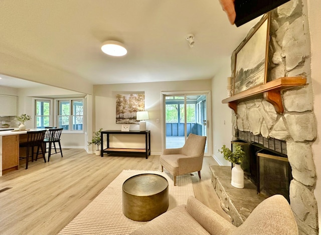 809 Wagon Wheel Trl, Mendota Heights, MN 55120 - living room featuring light wood-type flooring, a stone fireplace, and plenty of natural light
