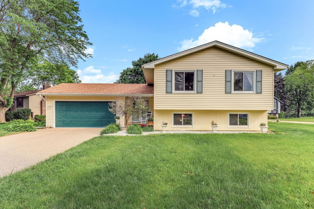 2261 Clark St, Eagan, MN 55122 - tri-level home with a garage, concrete driveway, a front yard, and a chimney