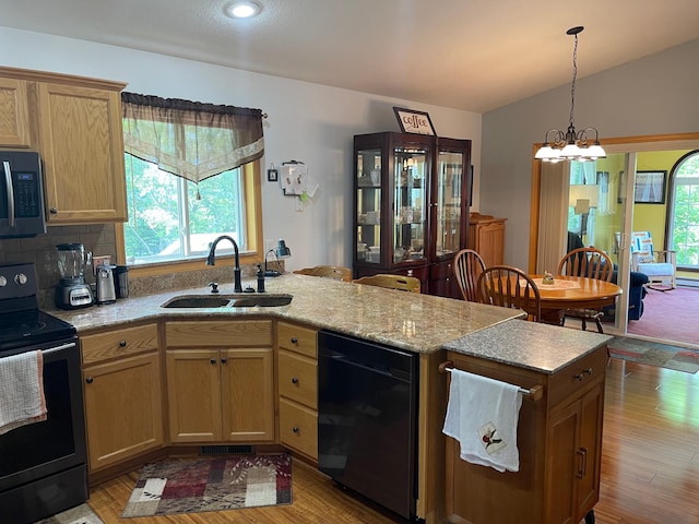 640 Meadowlark Ln, Eden Valley, MN 55329 - kitchen with black appliances, a peninsula, light wood-style flooring, pendant lighting, and vaulted ceiling