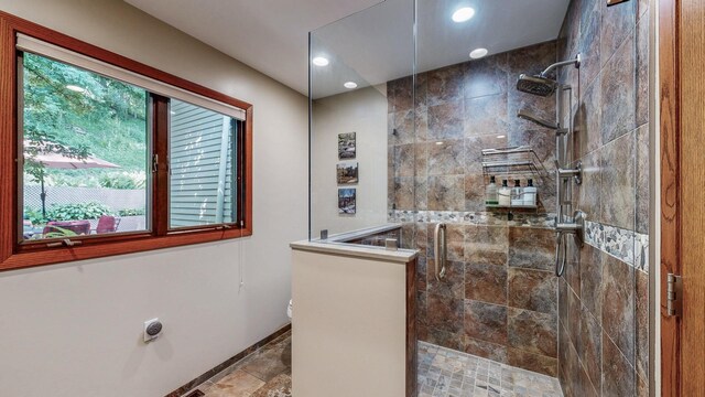 6317 Oak Meadow Ln NW, Rochester, MN 55901 - bathroom featuring a tile shower, recessed lighting, and stone finish floors