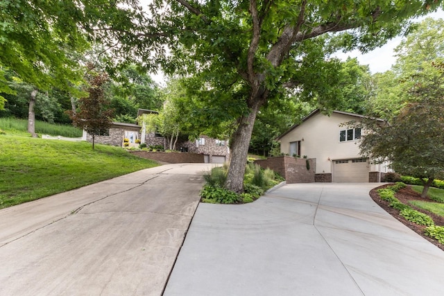 6317 Oak Meadow Ln NW, Rochester, MN 55901 - view of front of home with an attached garage, stone siding, driveway, and a front yard