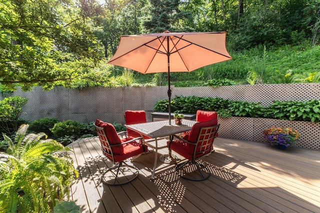 6317 Oak Meadow Ln NW, Rochester, MN 55901 - wooden terrace with outdoor dining space and view of wooded area