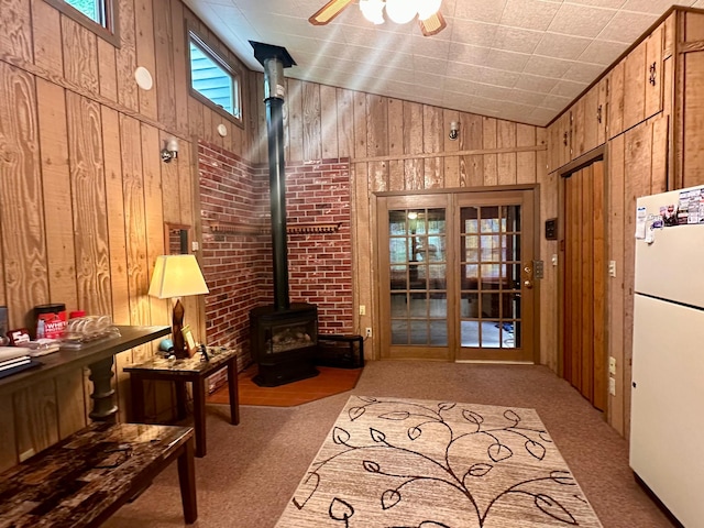 87102 Alder Loop, Sturgeon Lake, MN 55783 - interior space with freestanding refrigerator, a wood stove, wood walls, access to exterior, and high vaulted ceiling