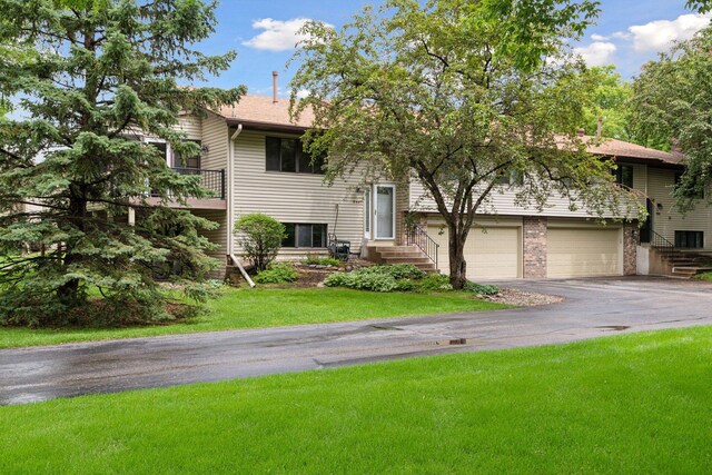 8447 Morgan Ln, Eden Prairie, MN 55347 - view of front facade with driveway, an attached garage, and a front lawn