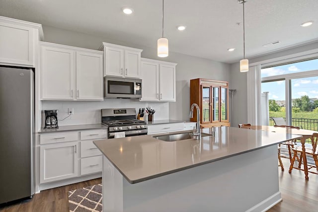 14145 Aberdeen Way, Rosemount, MN 55068 - kitchen with appliances with stainless steel finishes, dark wood finished floors, white cabinetry, recessed lighting, and a center island with sink