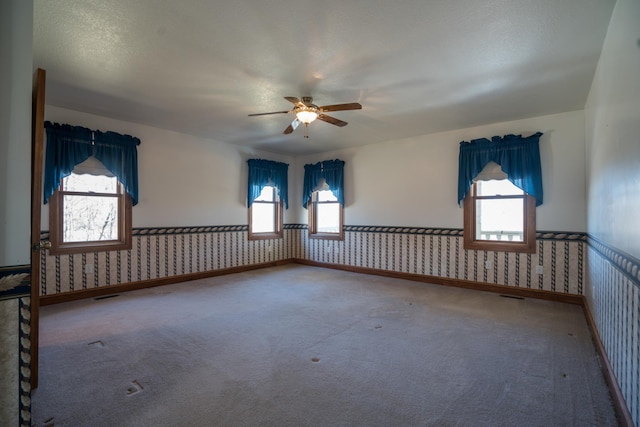1757 325th Ave, West Sweden Twp, WI 54837 - carpeted empty room featuring wainscoting, wallpapered walls, and ceiling fan