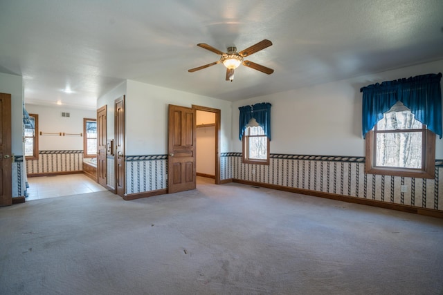 1757 325th Ave, West Sweden Twp, WI 54837 - empty room featuring ceiling fan, light carpet, wainscoting, and wallpapered walls