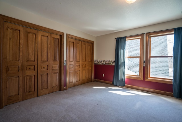 1757 325th Ave, West Sweden Twp, WI 54837 - unfurnished bedroom with multiple closets and carpet flooring