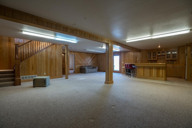 1757 325th Ave, West Sweden Twp, WI 54837 - below grade area featuring wooden walls, bar area, stairs, light colored carpet, and a textured ceiling