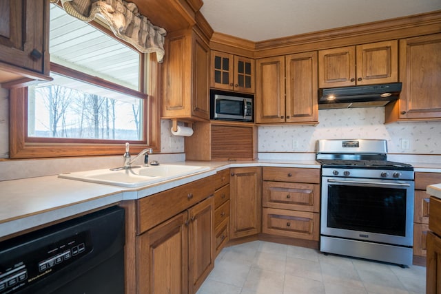 1757 325th Ave, West Sweden Twp, WI 54837 - kitchen featuring stainless steel appliances, under cabinet range hood, brown cabinetry, light countertops, and light tile patterned floors
