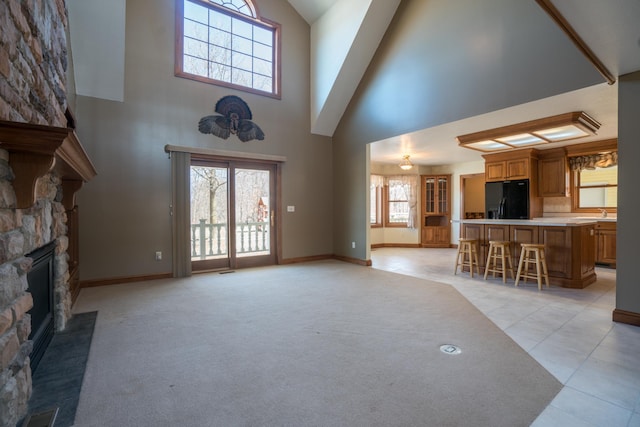 1757 325th Ave, West Sweden Twp, WI 54837 - unfurnished living room featuring high vaulted ceiling, a stone fireplace, and light tile patterned floors