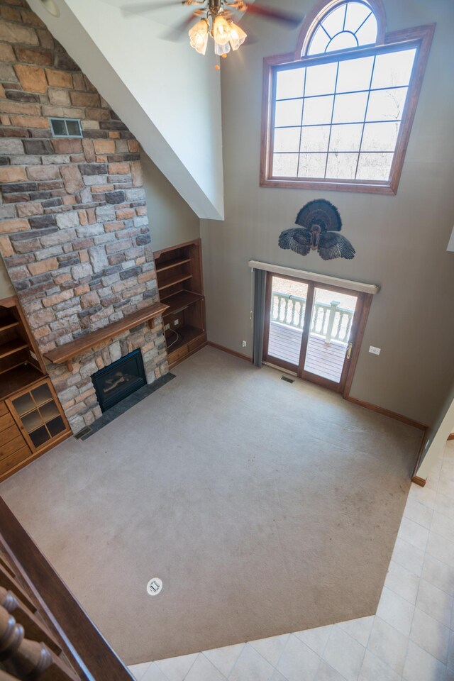 1757 325th Ave, West Sweden Twp, WI 54837 - unfurnished living room with ceiling fan, carpet, a stone fireplace, and a high ceiling