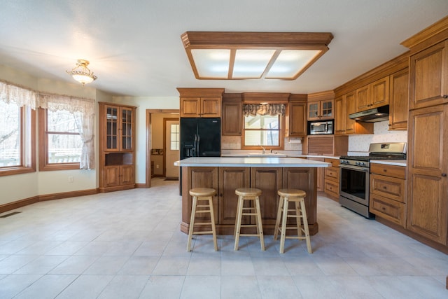 1757 325th Ave, West Sweden Twp, WI 54837 - kitchen with appliances with stainless steel finishes, under cabinet range hood, brown cabinetry, and healthy amount of natural light