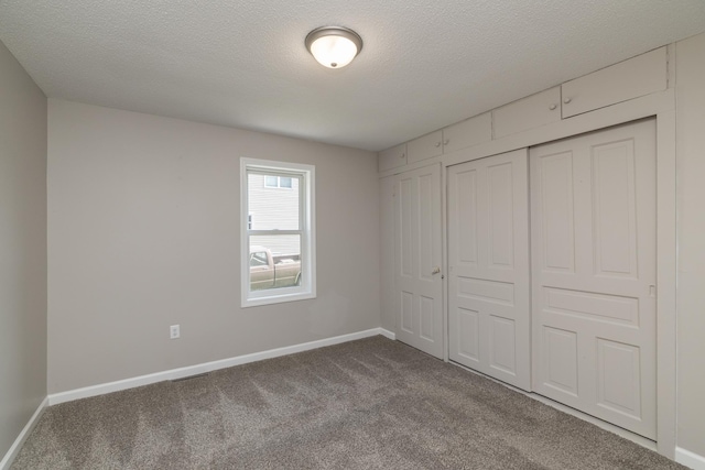269 Chestnut St, Ellsworth, WI 54011 - unfurnished bedroom with dark carpet, a textured ceiling, and a closet