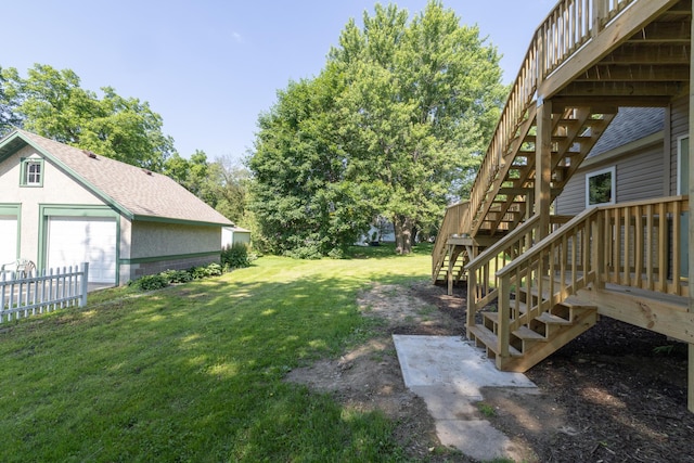 269 Chestnut St, Ellsworth, WI 54011 - view of grassy yard featuring stairs, a wooden deck, and a garage
