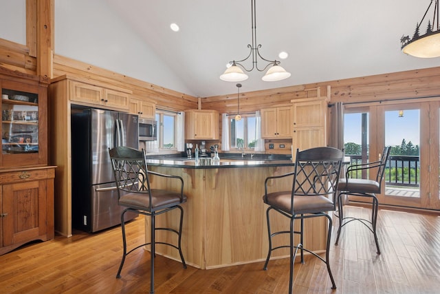 70824 227th St, Dassel Twp, MN 55325 - kitchen with appliances with stainless steel finishes, light brown cabinetry, dark countertops, a kitchen breakfast bar, and light wood-type flooring
