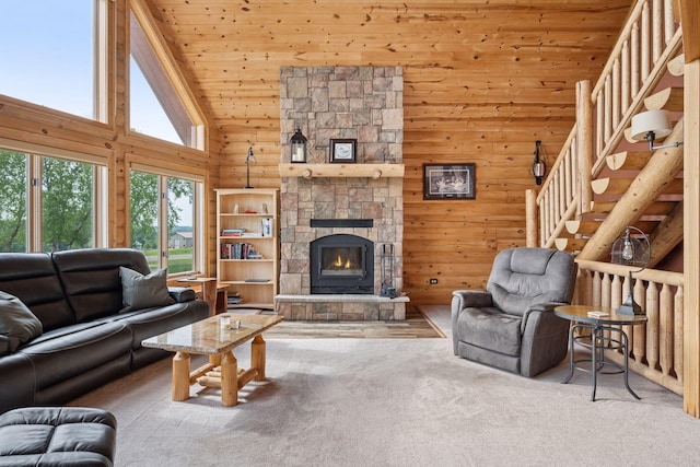 70824 227th St, Dassel Twp, MN 55325 - carpeted living area with high vaulted ceiling, wooden ceiling, a stone fireplace, wooden walls, and stairs