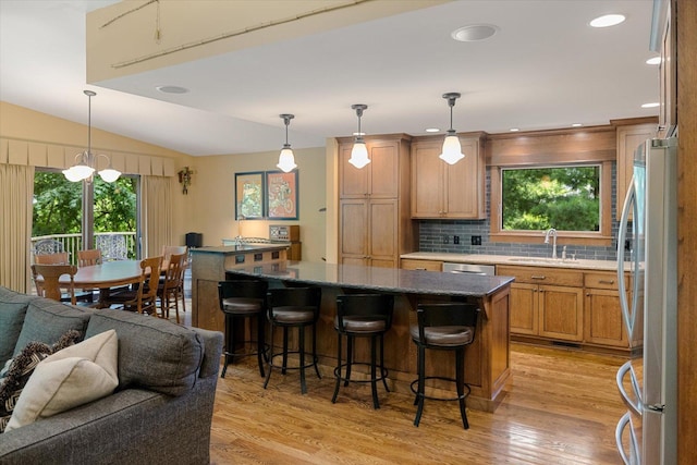 520 Wedgewood Ln N, Plymouth, MN 55441 - kitchen with stainless steel appliances, light wood finished floors, open floor plan, backsplash, and a kitchen bar