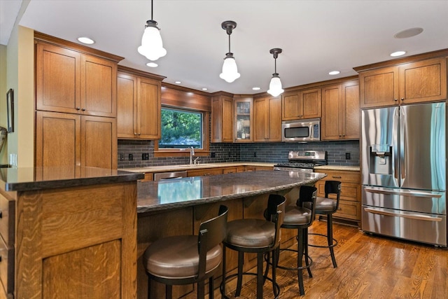 520 Wedgewood Ln N, Plymouth, MN 55441 - kitchen with stainless steel appliances, brown cabinets, dark wood finished floors, tasteful backsplash, and recessed lighting