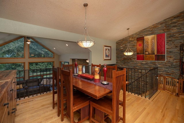 175 6th Ln NE, Oronoco, MN 55960 - dining space featuring wood finished floors, a textured ceiling, and high vaulted ceiling