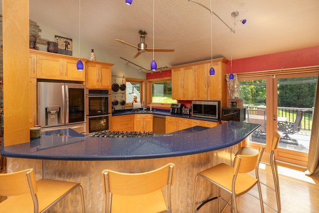 175 6th Ln NE, Oronoco, MN 55960 - kitchen featuring stainless steel appliances, lofted ceiling, healthy amount of natural light, a textured ceiling, and dark stone countertops