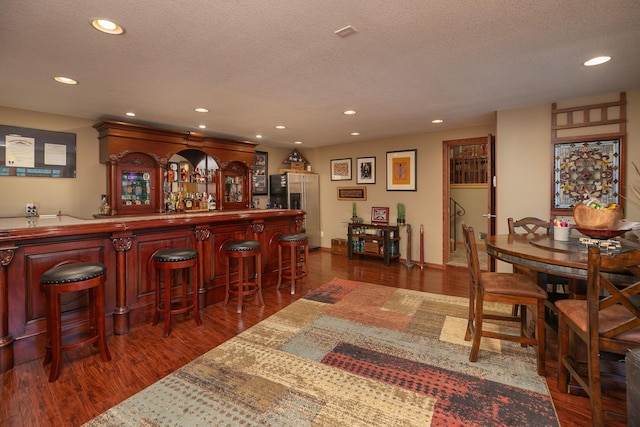 175 6th Ln NE, Oronoco, MN 55960 - indoor bar with stainless steel fridge with ice dispenser, recessed lighting, dark wood finished floors, and a textured ceiling