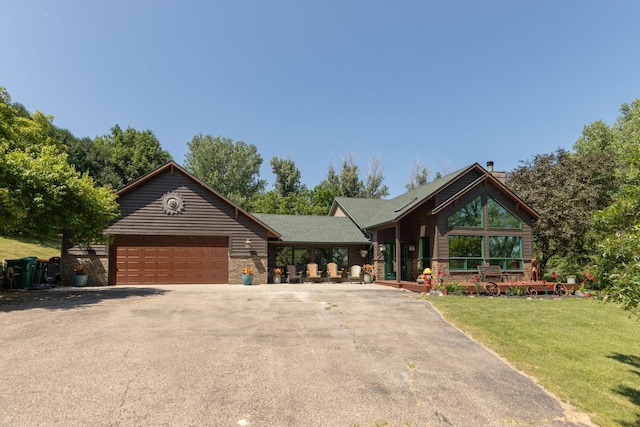 175 6th Ln NE, Oronoco, MN 55960 - view of front of home featuring driveway, a garage, a front lawn, stone siding, and a chimney