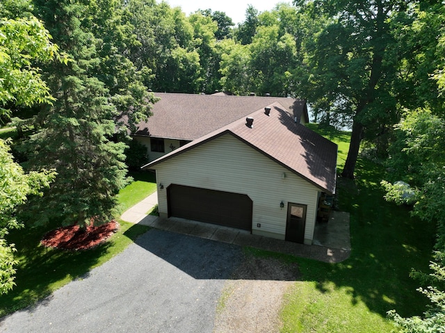 11160 Ottertail Point Dr NW, Cass Lake, MN 56633 - view of side of home with driveway, a shingled roof, a lawn, and an attached garage