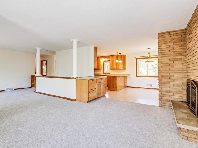 7651 86th St, Bloomington, MN 55438 - unfurnished living room with ornate columns, light carpet, and a brick fireplace