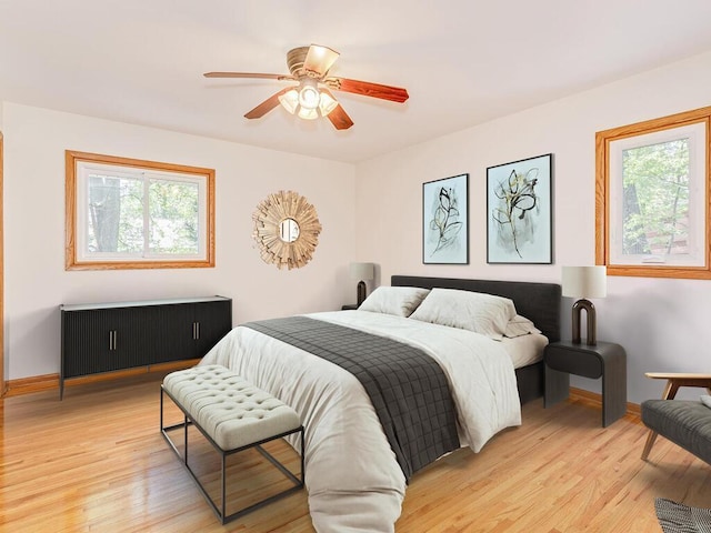 7651 86th St, Bloomington, MN 55438 - bedroom featuring multiple windows, light wood-style flooring, and a ceiling fan