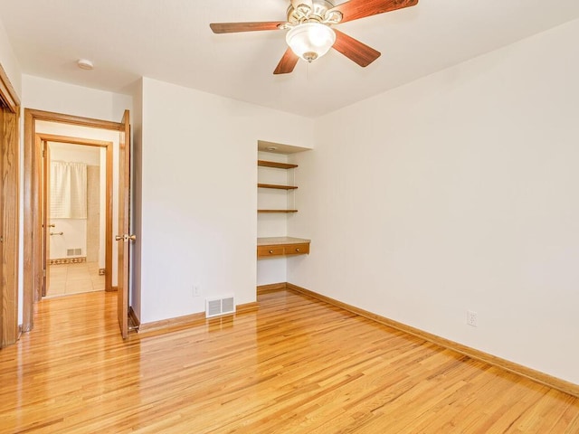 7651 86th St, Bloomington, MN 55438 - empty room featuring built in desk, light wood-type flooring, a smoke detector, and ceiling fan