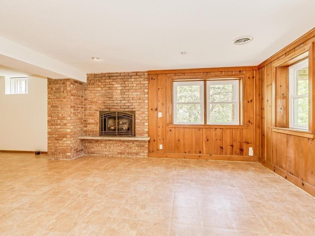 7651 86th St, Bloomington, MN 55438 - unfurnished living room featuring healthy amount of natural light, a fireplace, and wooden walls