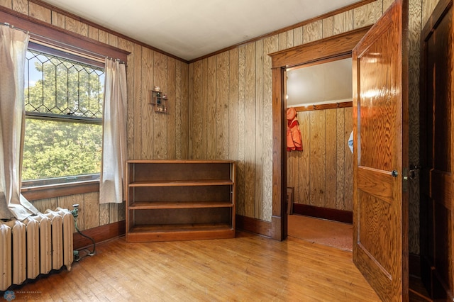 101 3rd Ave SW, Lidgerwood, ND 58053 - unfurnished bedroom with radiator, wood finished floors, multiple windows, wood walls, and ornamental molding