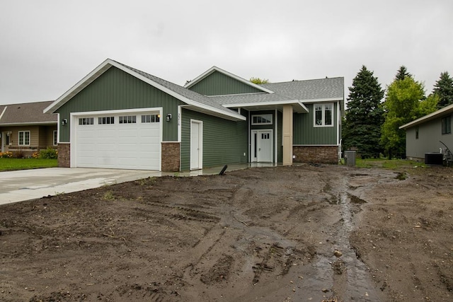 2216 Lake Ave, New Ulm, MN 56073 - view of front of house with an attached garage, board and batten siding, a shingled roof, and concrete driveway
