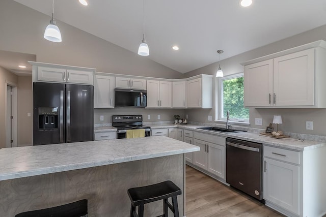 2216 Lake Ave, New Ulm, MN 56073 - kitchen with appliances with stainless steel finishes, a breakfast bar area, vaulted ceiling, white cabinets, and light countertops