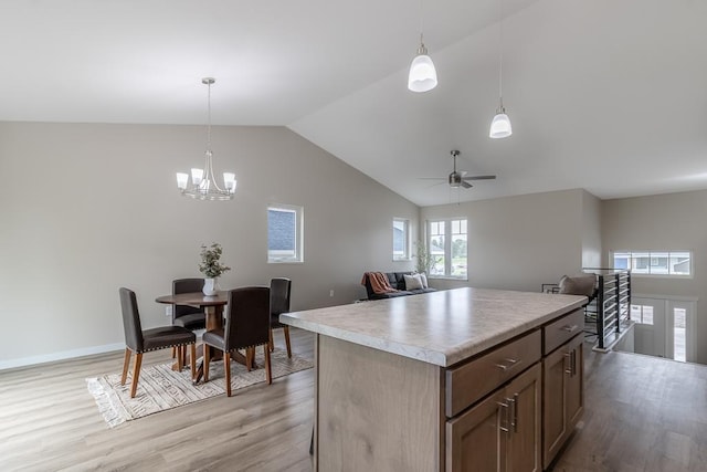 2216 Lake Ave, New Ulm, MN 56073 - kitchen featuring light wood-type flooring, light countertops, vaulted ceiling, a center island, and ceiling fan