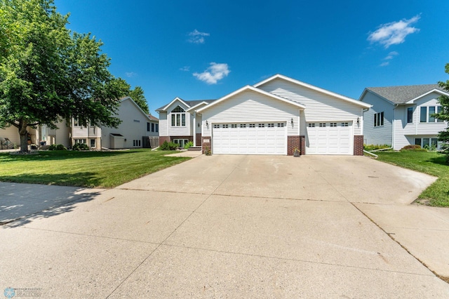 152 17th Ave W, West Fargo, ND 58078 - view of front of home featuring brick siding, a front lawn, a garage, and concrete driveway
