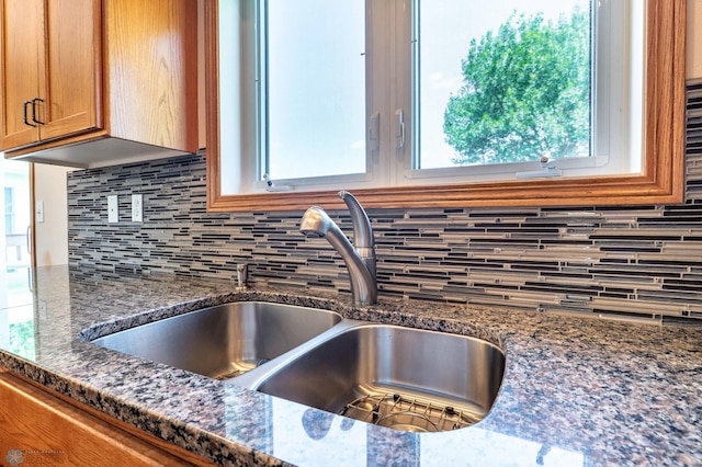 152 17th Ave W, West Fargo, ND 58078 - kitchen view of decorative backsplash, brown cabinets, and dark stone countertops