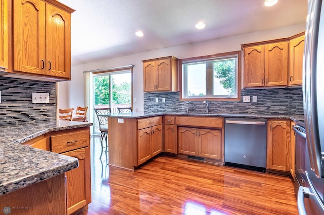 152 17th Ave W, West Fargo, ND 58078 - kitchen with appliances with stainless steel finishes, a peninsula, decorative backsplash, brown cabinetry, and recessed lighting