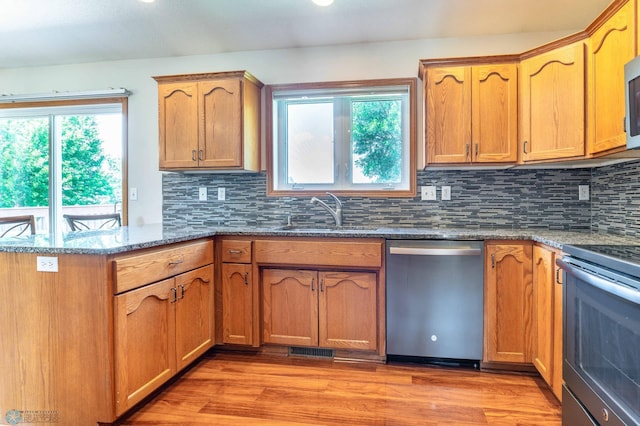 152 17th Ave W, West Fargo, ND 58078 - kitchen featuring appliances with stainless steel finishes, dark stone countertops, a peninsula, and healthy amount of natural light